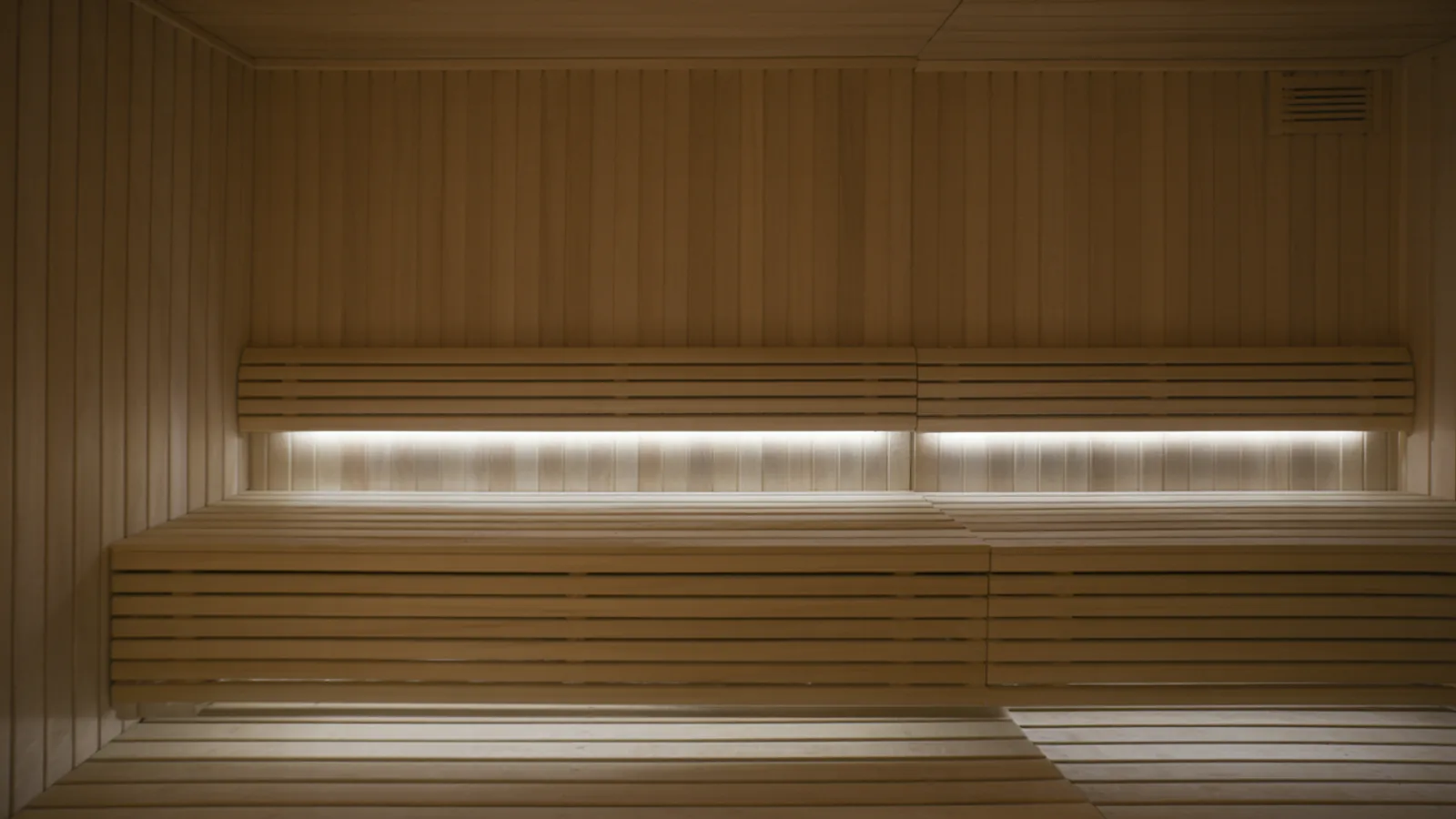 Sauna benches lit by a warm LED strip hidden under the upper bench backrest