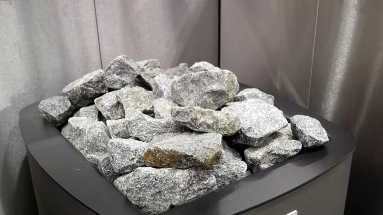 Split grey sauna stones piled on top of an electric sauna heater